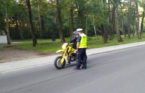 Policjant kontroluje motorowerzystę