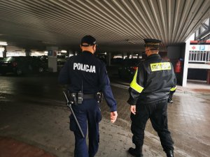 Policjant i strażnik miejski kontrolują sklepy