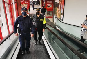 Policjant i strażnik miejski kontrolują sklepy