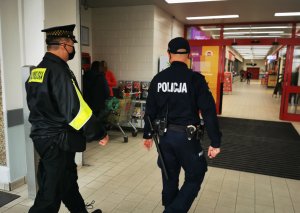 Policjant i strażnik miejski kontrolują sklepy