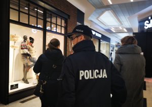 Policjant wraz z pracownikiem sanepidu w galerii handlowej kontroluje działalność sklepów