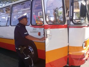 Policjant kontrolujący autobus