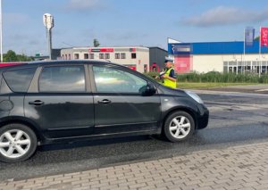 Policjanci przy rogatkach kolejowych wręczają kierowcom ulotki