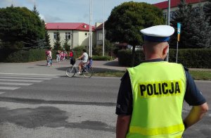 Policjant stojący przy przejściu dla pieszych przy szkole