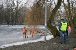 Policjanci nad zamarzniętym akwenem wodnym