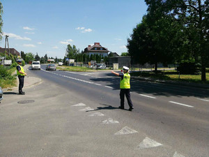 Patrol policjantów przy szkole, kontrolujący pieszych i pojazdy