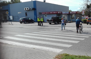 Patrol policjantów przy szkole, kontrolujący pieszych i pojazdy