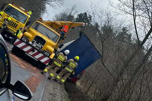 pojazd ciężarowy znajdujący się w rowie jest wyciągany przez pomoc drogową